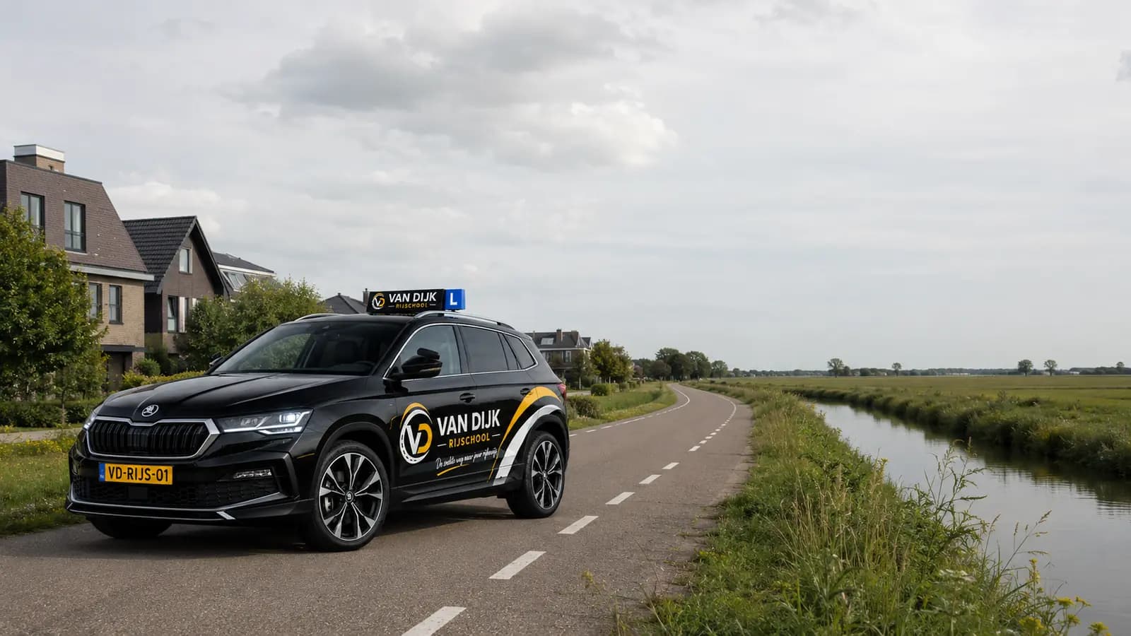 Zwarte Van Dijk Rijschool-lesauto op een weg tussen woongebied en polder bij Nootdorp