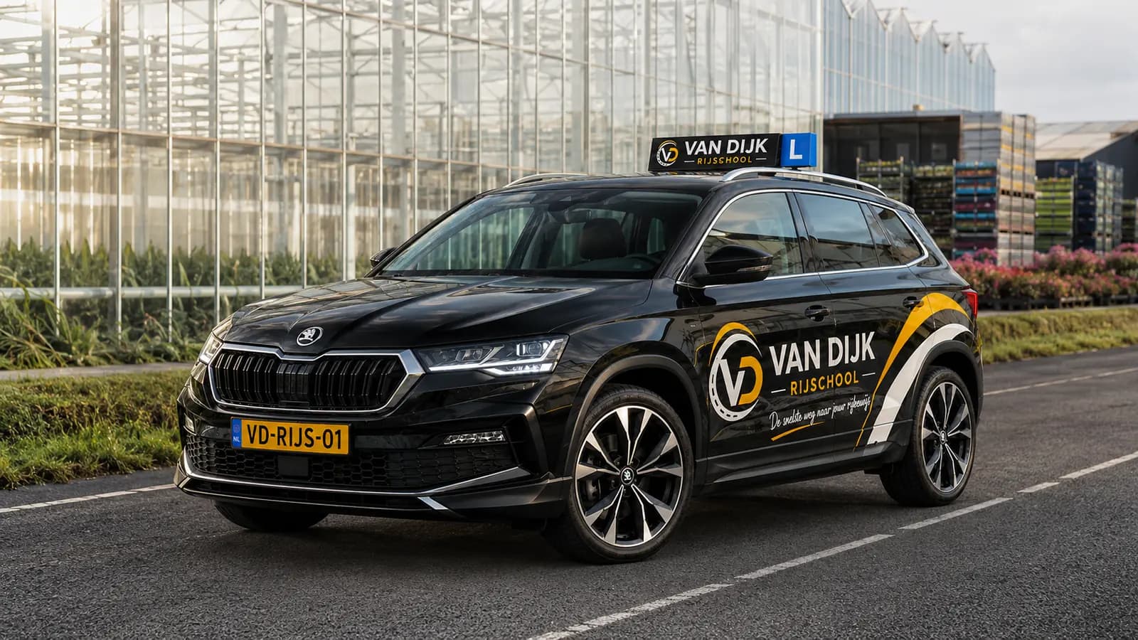 Zwarte Van Dijk Rijschool-lesauto tussen de kassen bij Honselersdijk
